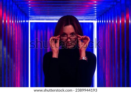 Portrait of an attractive girl standing in a futuristic room with neon light