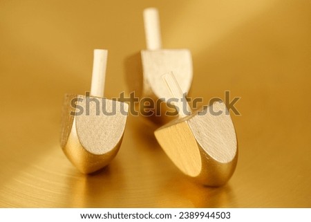 Jewish holiday Hanukkah background with wooden dreidels (spinning top). Golden baner Royalty-Free Stock Photo #2389944503