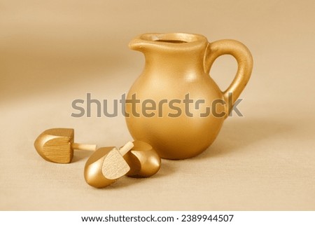 Jewish religious holiday Hanukkah with oil jug with wooden dreidels (spinning top). Golden baner
 Royalty-Free Stock Photo #2389944507