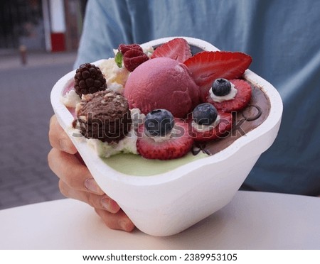 Closeup view of a man holding a gourmet ice cream pot with beautiful decoration                            