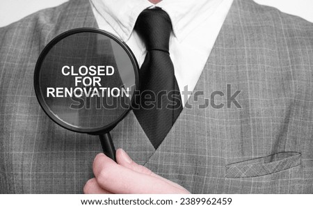 CLOSED FOR RENOVATION on magnifying glass and businessman