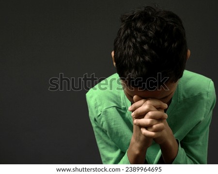 boy praying to God with hands held together with people sock image stock photo	