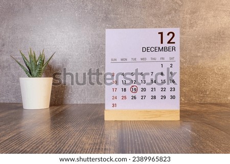 December 19st. Day 19 of month, daily calendar on white table with reflection, with light blue background. Winter time, empty space for text