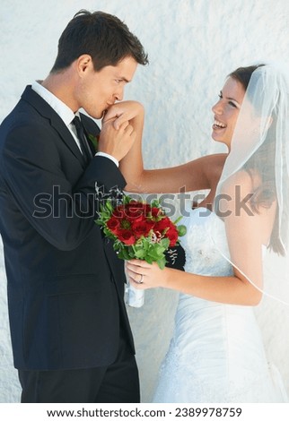 Romance, happy couple and kiss on hand at wedding with smile, bouquet and commitment at reception. Flowers, woman and man in embrace at marriage celebration with roses, loyalty and future together.