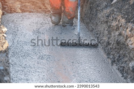 Concrete cast-in-place work. Builder level wet concrete. Concrete works on buildiiing construction site Royalty-Free Stock Photo #2390013543
