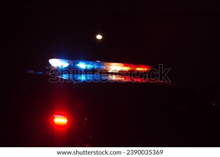 Showing a flashing, low profile police light at night background with advertisement space. 