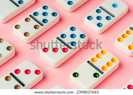 A pattern of domino pieces on pink background