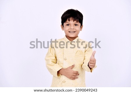 Indian little boy showing thumps up on white background