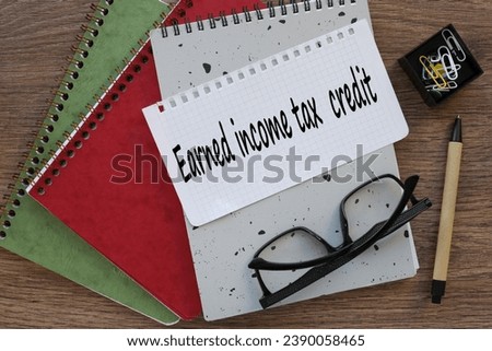 EARNED INCOME TAX CREDIT. page from a notepad with text. gray and red notepad