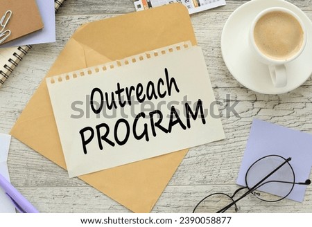 OUTREACH PROGRAM a cup of coffee. coffee. text on torn paper on an envelope Royalty-Free Stock Photo #2390058877