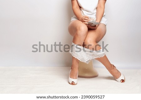 female legs with panties while sitting on the toilet