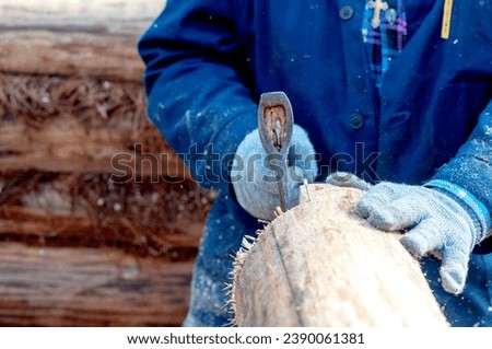 a carpenter builds a wooden house with an axe in his hand. High quality photo