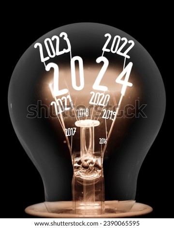 Single shining light bulb with fiber in a shape of New Year 2024 and years passed isolated on black background. Royalty-Free Stock Photo #2390065595