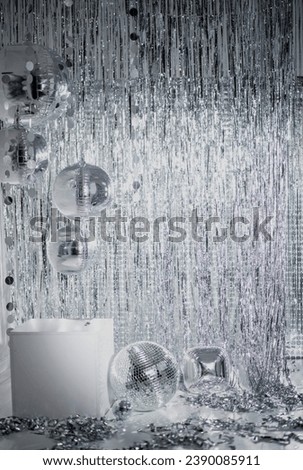 Shiny disco balls and foil fringe curtain indoors, toned in silver Royalty-Free Stock Photo #2390085911