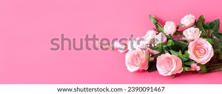 Bouquet of delicate artificial white roses on pink background. Decorative flowers in the interior of the house.