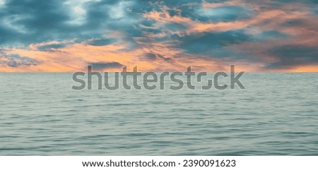 Cold season sunset sky, clouds and dark ocean surface without waves