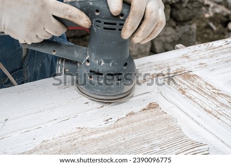 A carpenter repairs an old wooden door