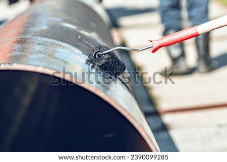 Metal pipe is painted with paint roller with black paint or bitumen. Protection of metal pipes from corrosion. Preparation of pipes for gasification.