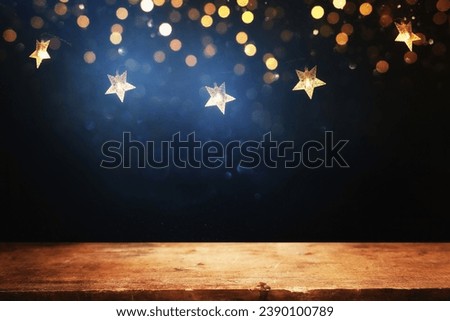 Empty wooden table in front of Christmas garland lights. ready for product presentation Royalty-Free Stock Photo #2390100789