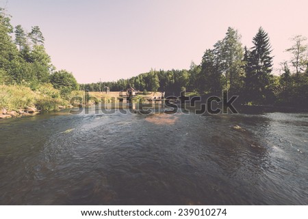 view to the mountain river in summer surrounded by forest and sandstone cliffs - vintage retro film look