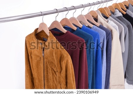 Row of colorful with sweatshirt ,sweater , suit,shirt, coat  hanging on wooden clothes hanger