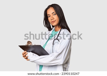 Young Filipina doctor reviewing a medical report in studio
