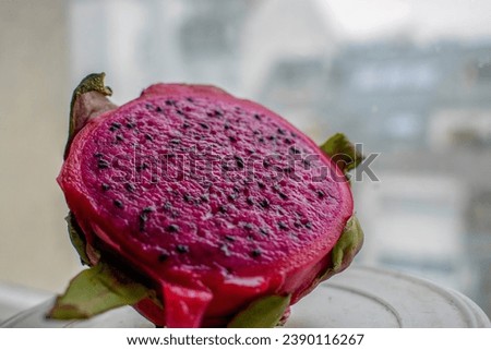 Red Pitaya Fruit, also known as Dragon Fruit. Fruit with the scaly exterior and the juicy, rosy interior with black seeds.