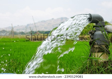 Fresh water from the ground is pumped using an electric compressor through pipes to the surface of the land to irrigate rice fields.