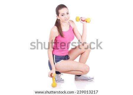 Young woman smiling while using dumbbells against a white background