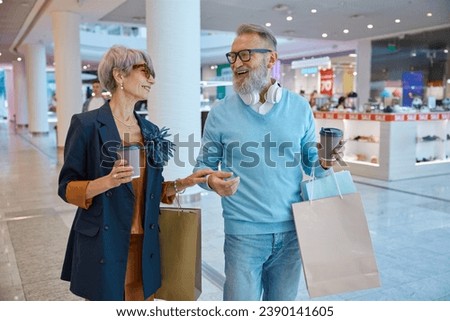 Fashionable elderly couple enjoying shopping tour on black friday weekends