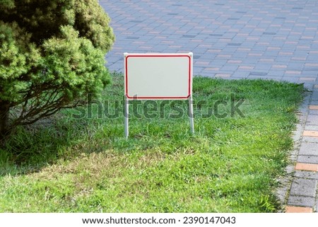 Pointer sign on the lawn green grass. Banner layout with place for the text dog walking is prohibited, do not walk on the lawn, it is dangerous, for sale. Information board layout. Mockup copy space