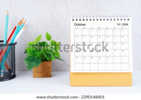 October 2024 Desk Calendar with pencil on white table.