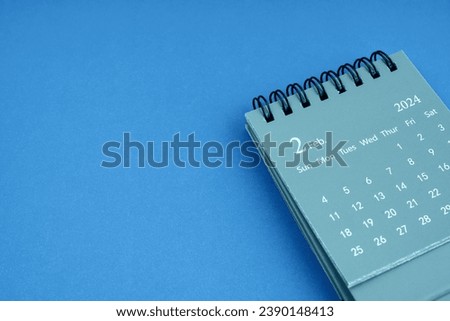 February 2024 desk calendar on blue color background. Copy space.