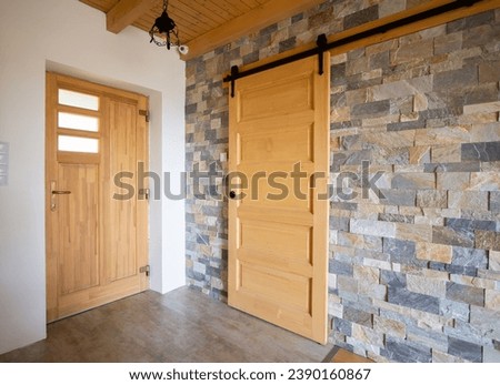Top hung hanging wooden barn sliding door with a grey brick wall Royalty-Free Stock Photo #2390160867