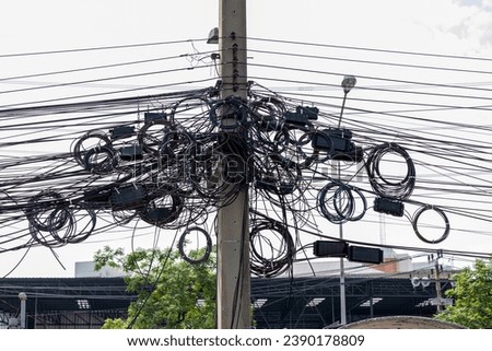 Intertwined electric wires. A tangled electrical wires showcasing the complexities of the city's power supply system. telephone wires and wireless provider cables. Royalty-Free Stock Photo #2390178809