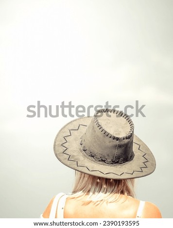 Back view picture of a woman wearing a elegant hat.