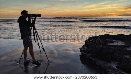 A photographer taking pictures at Swamis Beach Encinitas California USA. 