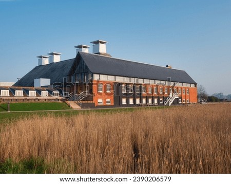 Snape, in the Coun ty of Suffolk, with its maltings and river Royalty-Free Stock Photo #2390206579