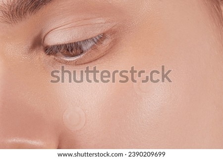 Girl with acne stick round acne patch on her cheek. Using acne patches for treatment of pimple and rosacea close-up. Facial rejuvenation cleansing cosmetology Royalty-Free Stock Photo #2390209699