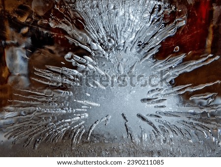 Ice with frozen air bubbles inside. Abstract winter cold decorative background in the form of an explosion. Close-up, selective focus