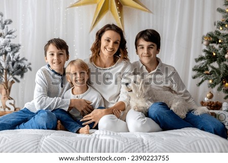 Happy family, children and mom, taking family pictures in a cozy christmas studio together