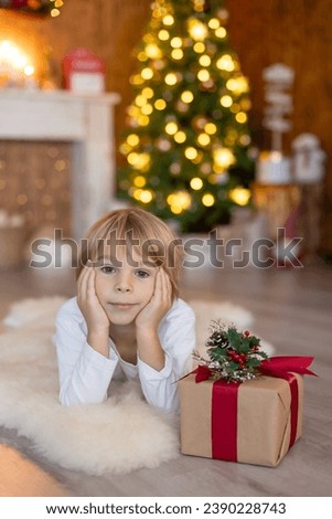 Happy child, boy, having pictures taken in a cozy christmas studio, childhood, happiness