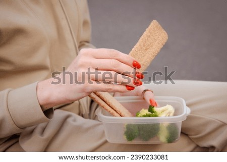 woman hand holding healthy snack with broccoli in lunch box Royalty-Free Stock Photo #2390233081