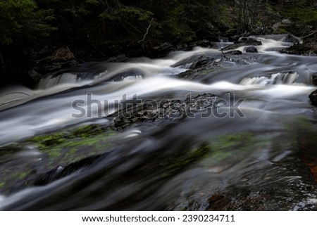 Stream of water with long exposure in dark Scandinavian forest