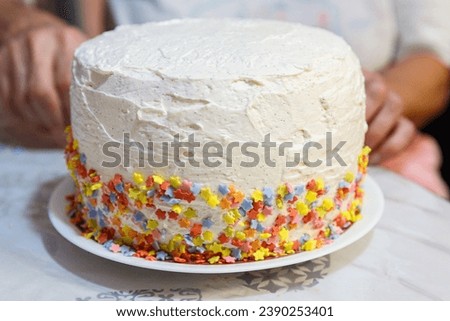 Colorful Crescendo: Decorating a Homemade Cake with Edible Stars Royalty-Free Stock Photo #2390253401