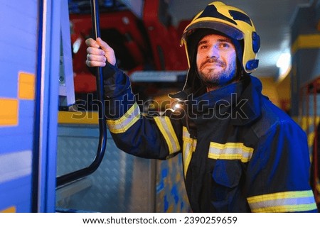 Portrait of male firefighter in uniform at fire station. Royalty-Free Stock Photo #2390259659