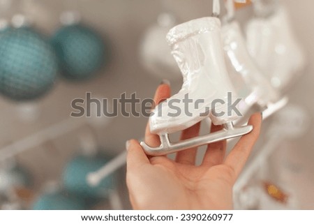 close up of a person holding a ice skates christmas tree ornament festive background with copy space. Shopping for xmas decor.