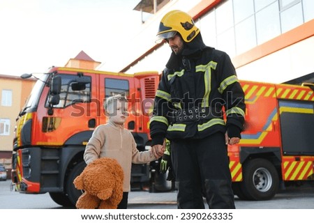Portrait of a fireman and a little boy with a teddy bear