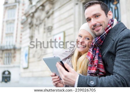 View of a Couple of young attractive tourist watching tablet 