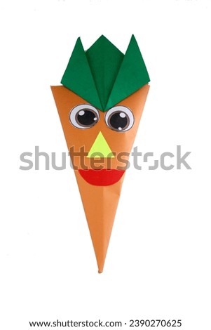 Origami doll in the shape of a cartoon carrot, made from paper and cotton inside